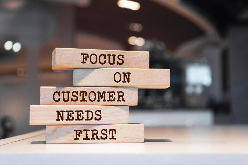 Wooden blocks with words ‘Focus on customer needs first’. Busine